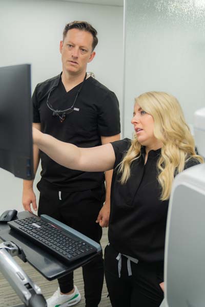 Dr. Warcup of North Texas Smiles in Fort Worth, TX discussing a patient's dental plan with his staff